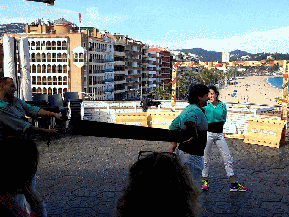 Wrapping a girdle around the waist of a casteller - Human towers in Catalonia