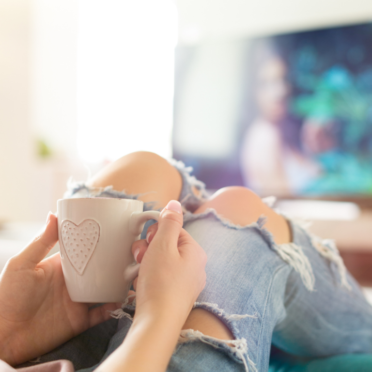 Canva Pro image of a woman watching TV while drinking coffee