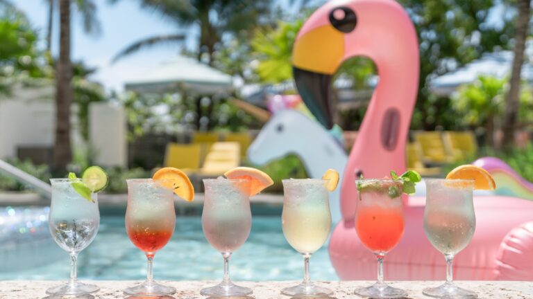 Colorful hotel - blow up flamingo with 5 cocktail glasses by the pool at The Confidante Hotel