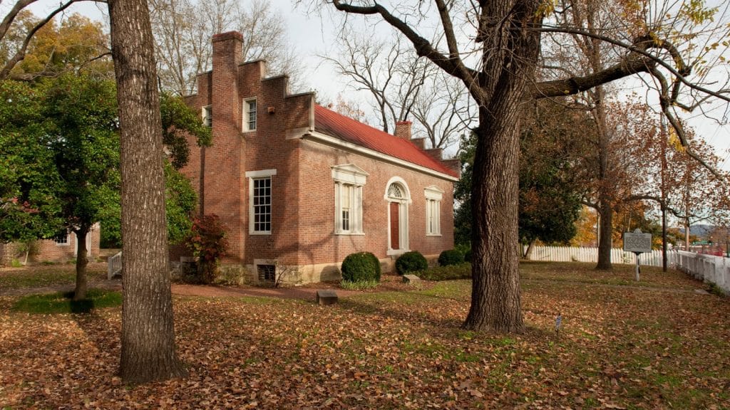 Battle of Franklin - Three Historic Sites Not to Miss in Franklin, TN 7 Carter House Photo Credit_ Courtesy Visit Franklin. Image of a house with a red door surrounded by trees and fall leaves on the ground.
